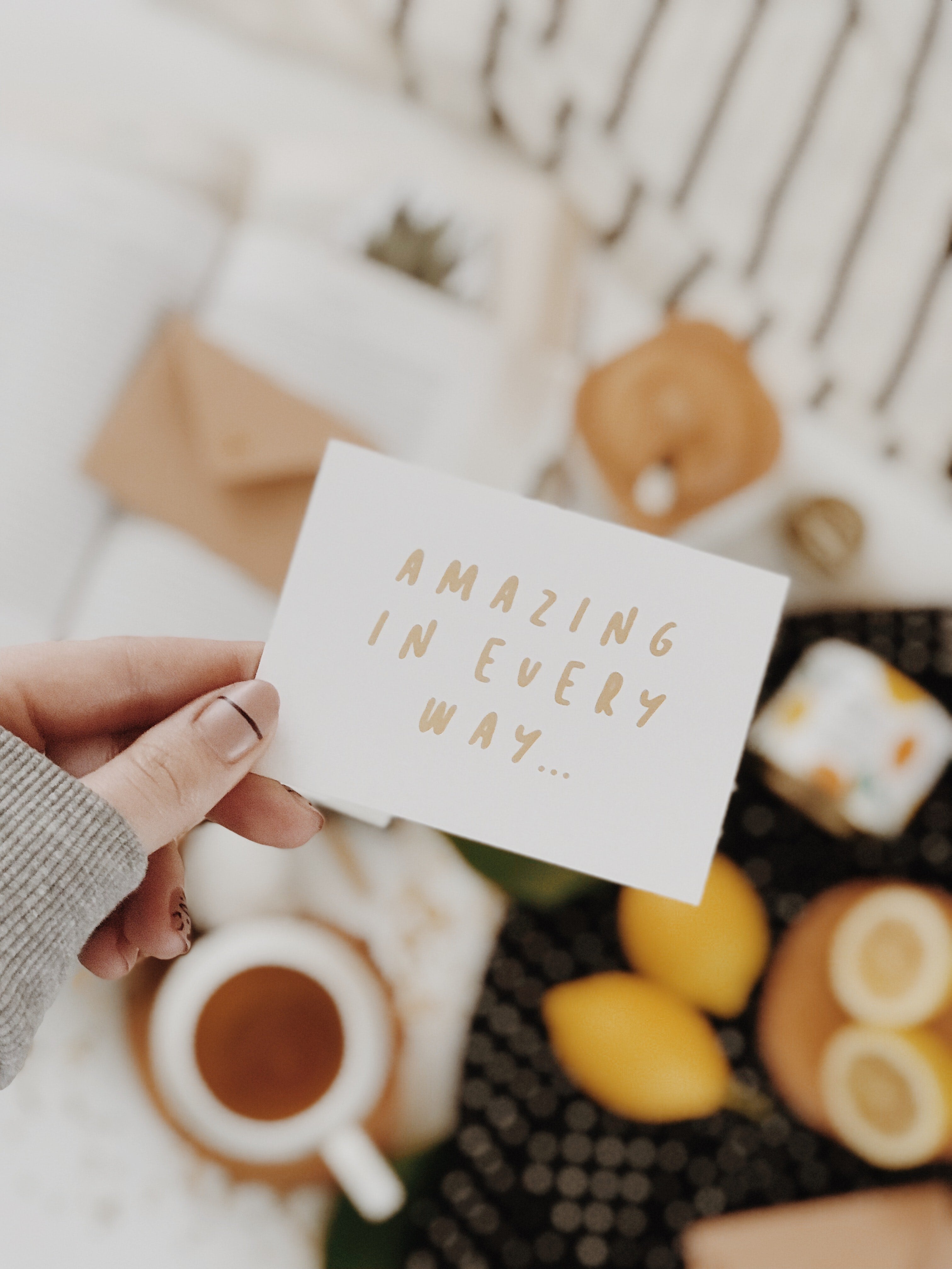 manicured hand holding a notecard that says "amazing in every way"